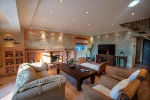 a large living room with couches and a fireplace at Aiolis Mediterranean Villa in Sounio