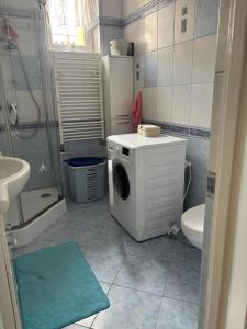 a bathroom with a washing machine and a toilet at Rooms near Balice airport in Cholerzyn