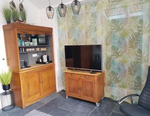 a living room with a television on a wooden cabinet at B&B Purmavida in Purmerend