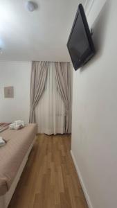 une chambre avec un lit et une télévision sur un mur dans l'établissement Sweet Saint Paul, à Rome