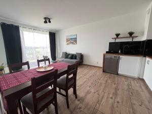 una cucina e una sala da pranzo con tavolo e sedie di Apartament Aquatower a Reda
