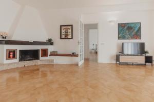 a large room with a wood floor and a fireplace at Villa Levante, relax esclusivo in riva al mare vicino Cefalù in Lascari