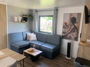 a living room with a blue couch and a window at Maison la Rivière in Gasselte
