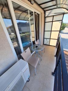 a balcony with a glass table and chairs at Goka apartments in Gevgelija
