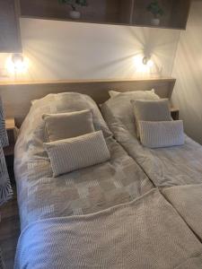 a large bed with two pillows on top of it at Maison la Rivière in Gasselte