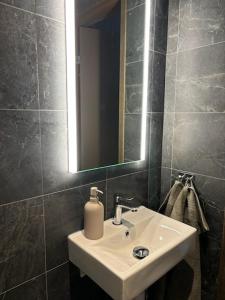 a bathroom with a white sink and a mirror at Luxury ski apartment - Lindvallen Sälen 365 Pool & Padel concept in Lindvallen +29 photos