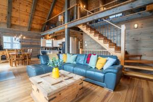 a living room with a blue couch and a table at L'Inukshuk - Chalet en bois ave Spa in Saint-Alexis-des-Monts +34 photos