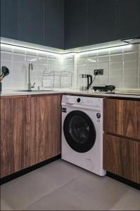 a kitchen with a washing machine and a sink at MaRKoS Sea View Apartment Bamboo Beach in Ts'ikhisdziri