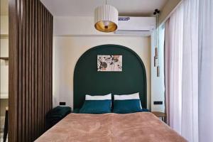 a bedroom with a bed with a green headboard at MaRKoS Sea View Apartment Bamboo Beach in Ts'ikhisdziri +14 photos
