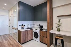 a kitchen with black cabinets and a washer and dryer at MaRKoS Sea View Apartment Bamboo Beach in Ts'ikhisdziri