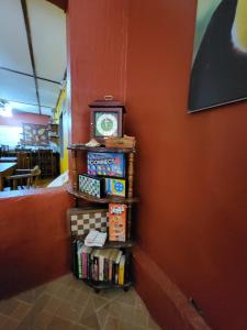 a shelf with books and a clock on a wall at Hotel Villa Prats in Manuel Antonio