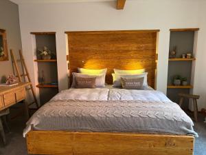 ein Schlafzimmer mit einem großen Bett mit hölzernem Kopfteil in der Unterkunft Neles Nest in Orlamünde