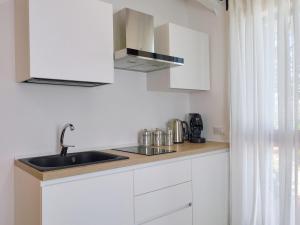 a kitchen with white cabinets and a sink at Casa Puffa - Tiny home in Baglio Rizzo