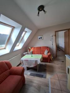 a living room with a red couch and a table at Fewo Abendsonne in Ueckeritz +50 photos
