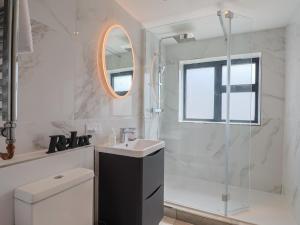 Un baño blanco con lavabo y ducha. en 1 Mill Green Court, en Lyme Regis 29 fotos más