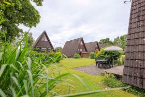 - un groupe de cottages avec une table et des chaises dans l'établissement Ferienwohnpark Immenstaad am Bodensee Nurdachhaus Typ 7 ND 50, à Immenstaad am Bodensee
