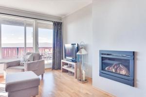 Una sala de estar con chimenea y televisión. en Big And Modern Apartment At Beitostølen, en Beitostølen