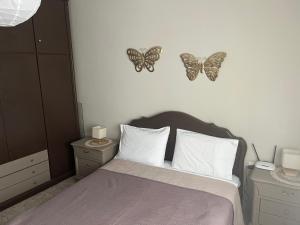 sypialnia z łóżkiem z motylami na ścianie w obiekcie Evi's House w mieście Limenas