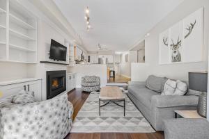 a living room with a couch and a fireplace at Blue Mountain Haus - Private Patio - Walk to Blue in Blue Mountains