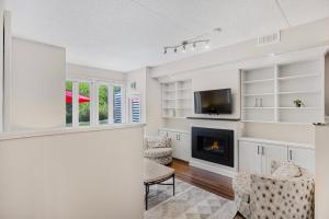 a living room with a fireplace and a tv at Blue Mountain Haus - Private Patio - Walk to Blue in Blue Mountains