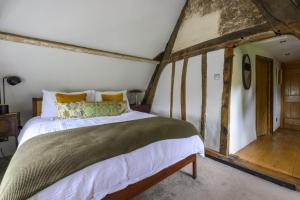 ein Schlafzimmer mit einem großen Bett in einem Zimmer in der Unterkunft Cruck Cottage in Fordingbridge