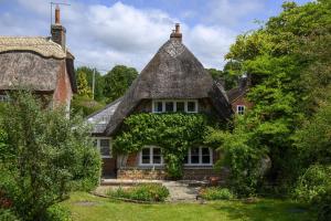 ein altes Haus mit einem Strohdach in der Unterkunft Cruck Cottage in Fordingbridge + 54 Fotos