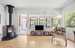 a living room with a fireplace and a chair at 2 Bedroom Gorgeous Home In Holbæk in Holbæk