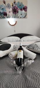 a bottle of wine sitting on top of a bed at APP Tilia in Crikvenica