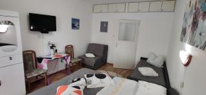 Una pequeña sala de estar con un sofá y un televisor. en APP Tilia, en Crikvenica