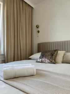 a bedroom with two beds and a window with curtains at Apartament Echo Park in Olecko