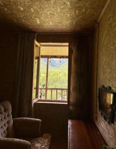 a room with a couch and a window with a view at Qvis Sakhli in Tvebishi