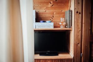 a tv in a wooden cabinet with a television at Legatum Cottage  +28 photos