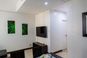 sala de estar con paredes blancas y TV de pantalla plana en Pedersen Condo, en Cebú