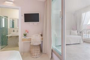 a bedroom with a desk and a bed and a tv at La Rosa dei Venti Guesthouse in Villasimius