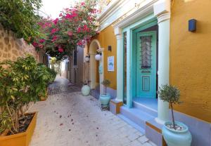 a narrow alley with a blue door and flowers at Alley studio 1 by Frangki in Aegina Town