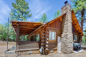 a log cabin with a stone chimney at Cowboy Cabin in Pinetop-Lakeside