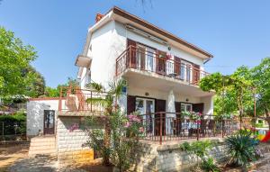 a white house with balconies and flowers at 1 Bedroom Nice Apartment In Pinezici in Pinezici