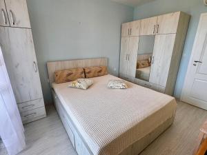 a bedroom with a bed with wooden cabinets at Sea View Apartment in Aurora Complex, Steps from the Beach in St. St. Constantine and Helena