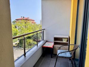 a balcony with a chair and a table and a window at Sea View Apartment in Aurora Complex, Steps from the Beach in St. St. Constantine and Helena