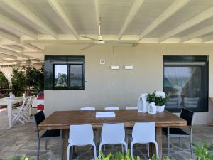 a dining room with a wooden table and chairs at Κ2 VILLA from k2properties in Pefkochori