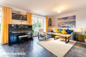 un salon avec un piano et un canapé dans l'établissement Wattkieker, à Utersum