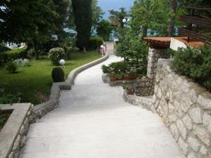 a stone path in a garden with a stone wall at Marina Apartment in Crikvenica