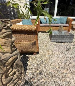 a patio with wicker chairs and a couch at Am Weinberg - stilvoll, ruhig, zum wohlfühlen in Pfaffenweiler