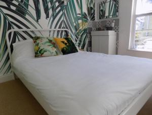a white bed with two pillows in a bedroom at Sea Bed Guesthouse in Newquay