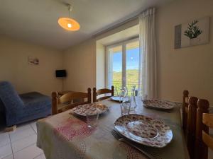 a dining room with a table with plates on it at La Vallée Appartement 36 - Thermes Neyras les Bains in Meyras