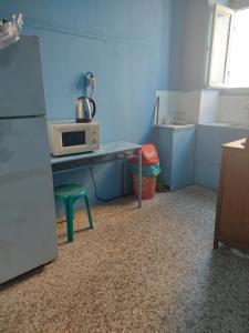 a kitchen with a microwave and a table with a microwave at SHARING ROOM IN NEAR THISSIO METRO STATION BY ACROPOLIs in Athens
