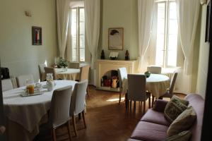 a dining room with tables and chairs and a fireplace at B&B Del Vescovado in Reggio Emilia
