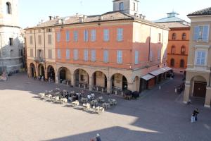 a group of people sitting at tables outside a building at B&B Del Vescovado in Reggio Emilia