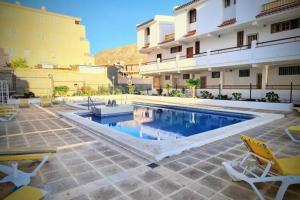 a swimming pool in front of a building at Joy & Friends 1 in Los Cristianos