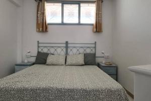 a bedroom with a large bed with a window at Joy & Friends 1 in Los Cristianos +10 photos